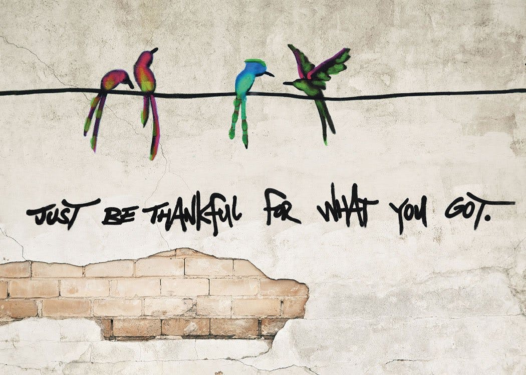 « Just be thanful for what you got », affiche avec graffiti