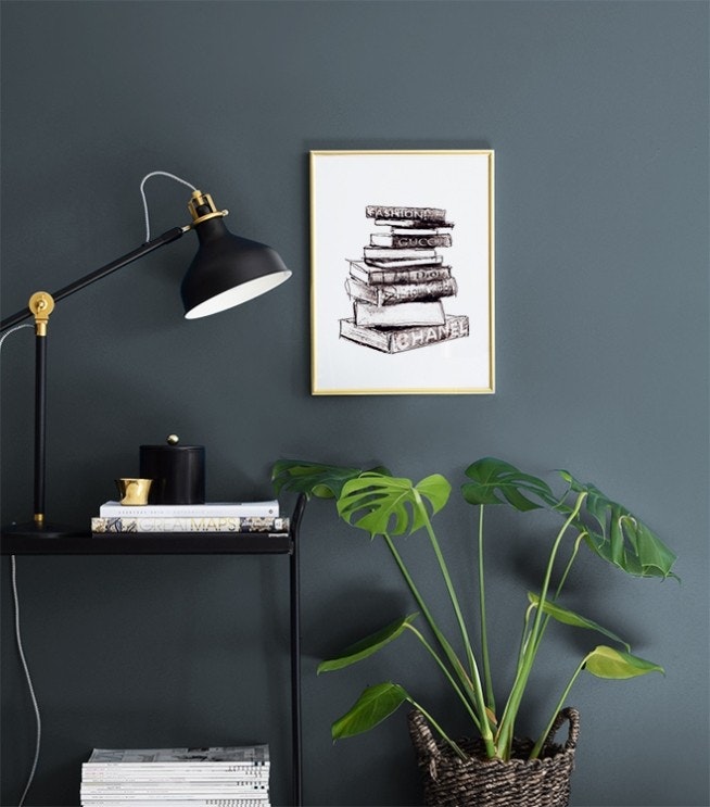 Posters with books above a beige sofa