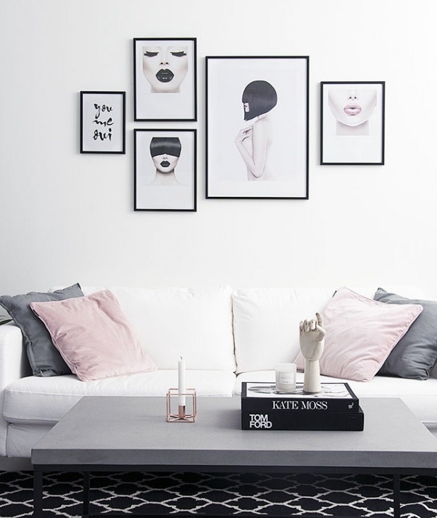 Black and white photos with hints of pink, on a photography wall