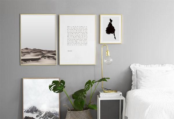 Posters guldramar i sovrum, mot grå vägg