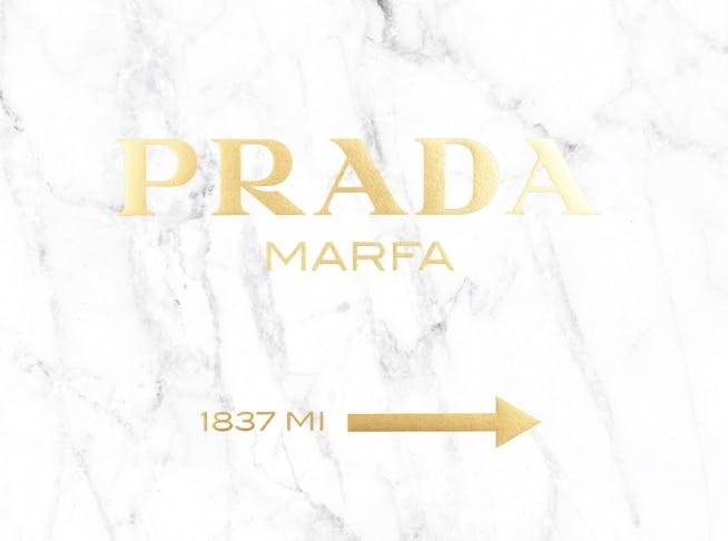 Print with a gold text Prada Marfa against a marble background